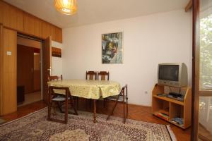 a living room with a table and a television at Apartments by the sea Starigrad, Paklenica - 6626 in Starigrad