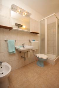 a bathroom with a toilet and a sink and a shower at Apartments by the sea Starigrad, Paklenica - 6626 in Starigrad