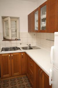 a kitchen with wooden cabinets and a sink at Apartments by the sea Starigrad, Paklenica - 6626 in Starigrad