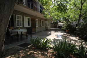 a patio with a table and chairs in front of a building at Apartments by the sea Starigrad, Paklenica - 6626 in Starigrad