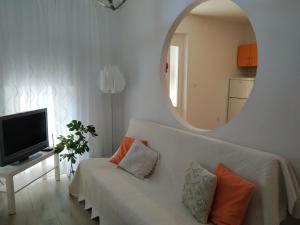 a living room with a white couch and a mirror at Apartments by the sea Podgora, Makarska - 6664 in Podgora