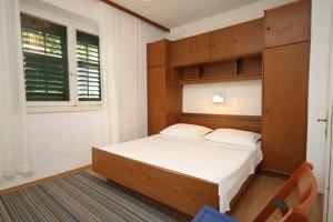 um pequeno quarto com uma cama e uma janela em Apartments by the sea Podgora, Makarska - 6664 em Podgora