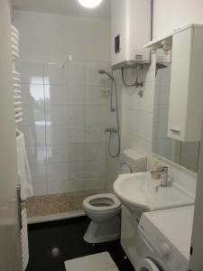 uma casa de banho branca com um WC e um lavatório em Apartments by the sea Podgora, Makarska - 6780 em Podgora