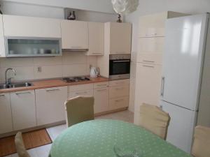 uma cozinha com uma mesa e um frigorífico branco em Apartments by the sea Podgora, Makarska - 6780 em Podgora