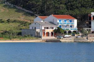 a house on the shore of a body of water at Apartments by the sea Metajna, Pag - 6465 in Metajna
