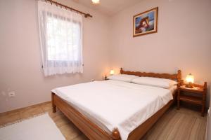 - une chambre avec un grand lit et une fenêtre dans l'établissement Apartments with a parking space Starigrad, Paklenica - 6566, à Starigrad-Paklenica