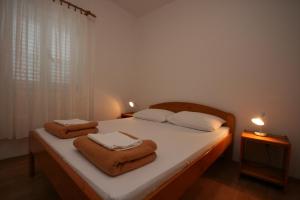 a bedroom with a bed with towels on it at Apartments with parking space Gradac, Makarska - 6724 in Gradac