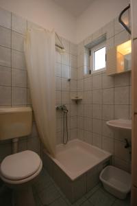 a bathroom with a tub and a toilet and a sink at Apartments with a parking space Gradac, Makarska - 6724 in Gradac