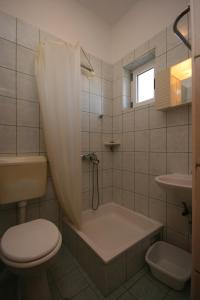 a bathroom with a tub and a toilet and a sink at Apartments with parking space Gradac, Makarska - 6724 in Gradac +20 photos