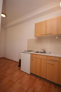 an empty kitchen with wooden cabinets and a sink at Apartments with parking space Gradac, Makarska - 6724 in Gradac