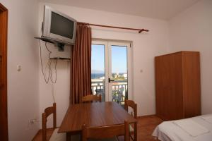 a room with a table and a television and a balcony at Apartments with a parking space Gradac, Makarska - 6724 in Gradac