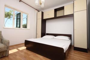 um quarto com uma cama grande e uma janela em Apartments with a parking space Makarska - 6791 em Makarska