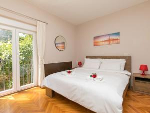 una camera da letto con un grande letto bianco con fiori di Apartments with a parking space Porec - 6922 a Poreč (Parenzo)