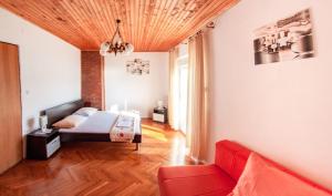 salon z czerwoną kanapą i łóżkiem w obiekcie Apartments by the sea Pag - 6448 w mieście Pag