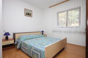 Schlafzimmer mit einem Bett und einem Fenster in der Unterkunft Apartments by the sea Lun, Pag - 6450 in Lun