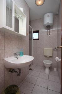 uma casa de banho com um lavatório e um WC em Apartments by the sea Lun, Pag - 6450 em Lun