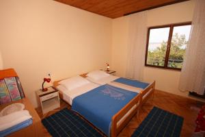 sypialnia z dużym łóżkiem i oknem w obiekcie Apartments by the sea Starigrad, Paklenica - 6589 w mieście Starigrad-Paklenica