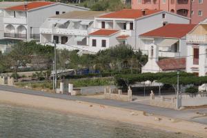 una fila de casas en la orilla de una playa en Apartments by the sea Metajna, Pag - 6486, en Metajna