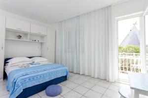 a bedroom with a bed and a large window at Apartments by the sea Podgora, Makarska - 6671 in Podgora