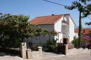 una casa blanca con una valla de piedra delante de ella en Apartments by the sea Slatine, Ciovo - 6888 en Trogir