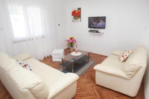una sala de estar con 2 sofás blancos y una mesa. en Apartments by the sea Slatine, Ciovo - 6888 en Trogir