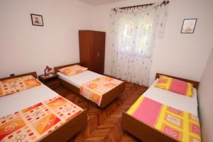 Habitación con 3 camas y ventana en Apartments by the sea Slatine, Ciovo - 6888 en Trogir