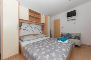 a bedroom with a bed and a couch and a television at Apartments with a parking space Tucepi, Makarska - 6856 in Tučepi