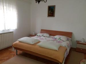 a bedroom with a bed with pillows and a window at Apartments with a parking space Tar, Porec - 6943 in Tar