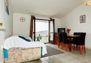a bedroom with a bed and a table and a window at Apartments by the sea Pirovac, Sibenik - 6447 in Pirovac