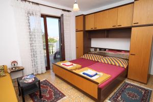 a small bedroom with a bed and a balcony at Apartments and rooms by the sea Povljana, Pag - 6476 in Povljana