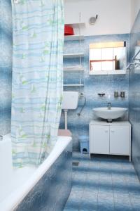 La salle de bains est pourvue d'un lavabo et d'un rideau de douche. dans l'établissement Apartments and rooms by the sea Povljana, Pag - 6476, à Povljana