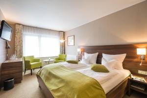 ein Hotelzimmer mit einem großen Bett und einem Schreibtisch in der Unterkunft Relax-Hotel Pip-Margraff in Sankt Vith