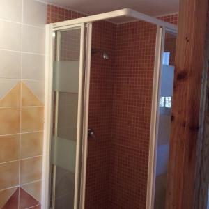 een douche met een glazen deur in de badkamer bij La Haza in Frigiliana