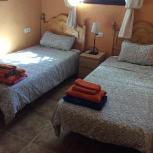 sypialnia z dwoma łóżkami i ręcznikami na siedzeniu w obiekcie La Haza w mieście Frigiliana