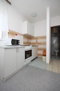 a kitchen with white cabinets and a microwave at Apartments with a parking space Zubovici, Pag - 6520 in Zubovići