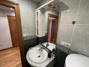 a bathroom with a sink and a mirror at Gijón Playa by FlowHome in Gijón +27 photos