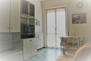 uma cozinha com uma mesa e uma televisão num quarto em Appartamento Il Porticciolo em Marina dʼAndora