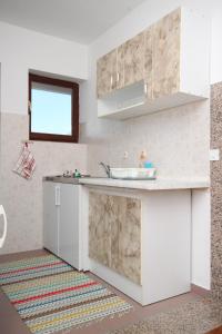 a kitchen with white cabinets and a sink at Apartments and rooms by the sea Starigrad, Paklenica - 6591 in Starigrad