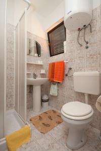 a bathroom with a toilet and a sink and a shower at Apartments and rooms by the sea Starigrad, Paklenica - 6591 in Starigrad-Paklenica +46 photos