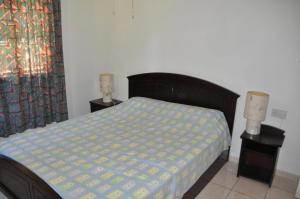 een slaapkamer met een bed en twee lampen op tafels bij La Colombe D'Or in Grand'Anse Praslin