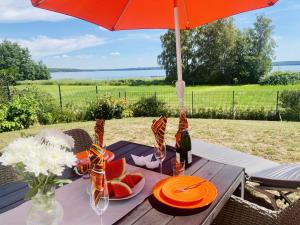 - une table de pique-nique avec un parasol et une assiette de fruits dans l'établissement Ferienhäuser mit Seeblick direkt am Plauer See, à Plau am See