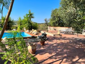 un patio con piscina, mesa y árboles en Blu Daddy, en Itri