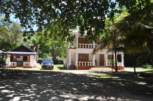 um carro estacionado em frente a uma casa em La Colombe D'Or em Grand'Anse Praslin