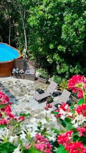 a patio with chairs and flowers and a swimming pool at Cozy & Good Vibes Villa Castana. in Romagnese