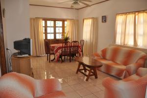 uma sala de estar com um sofá e uma mesa em La Colombe D'Or em Grand'Anse Praslin
