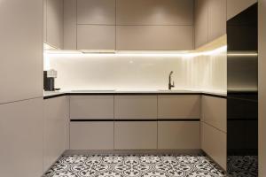 a kitchen with white cabinets and a tile floor at LUXURY APARTMENT Benalmadena Costa in Benalmádena