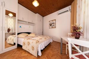 a bedroom with a bed and a desk in it at Apartments with a parking space Tucepi, Makarska - 6695 in Tučepi