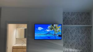 een flatscreen-tv hangend aan een muur in een badkamer bij Camiño da Praia in Redondela
