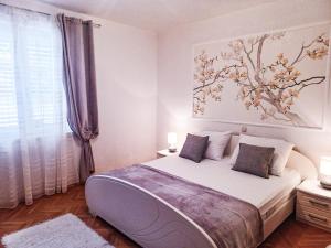 - une chambre avec un lit et une peinture murale dans l'établissement Apartments and rooms with parking space Makarska - 6767, à Makarska