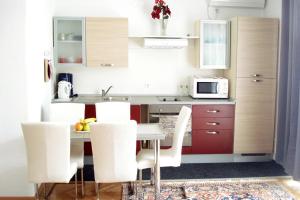 - une petite cuisine avec une table et des chaises blanches dans l'établissement Apartments and rooms with parking space Makarska - 6767, à Makarska